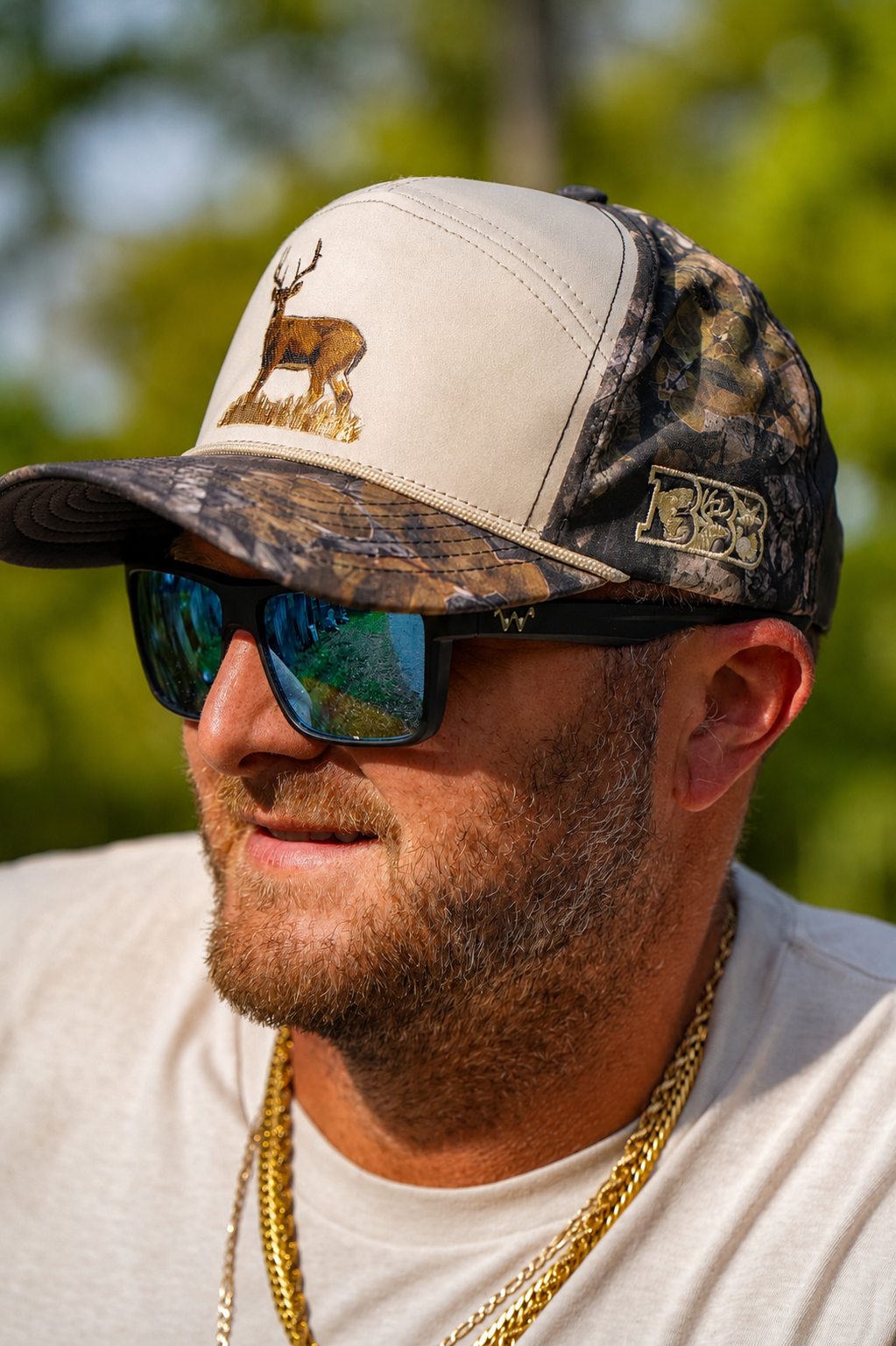 Zach Rushing wearing a two toned camo bbb outdoors trucker hat with a deer embroidered on the front